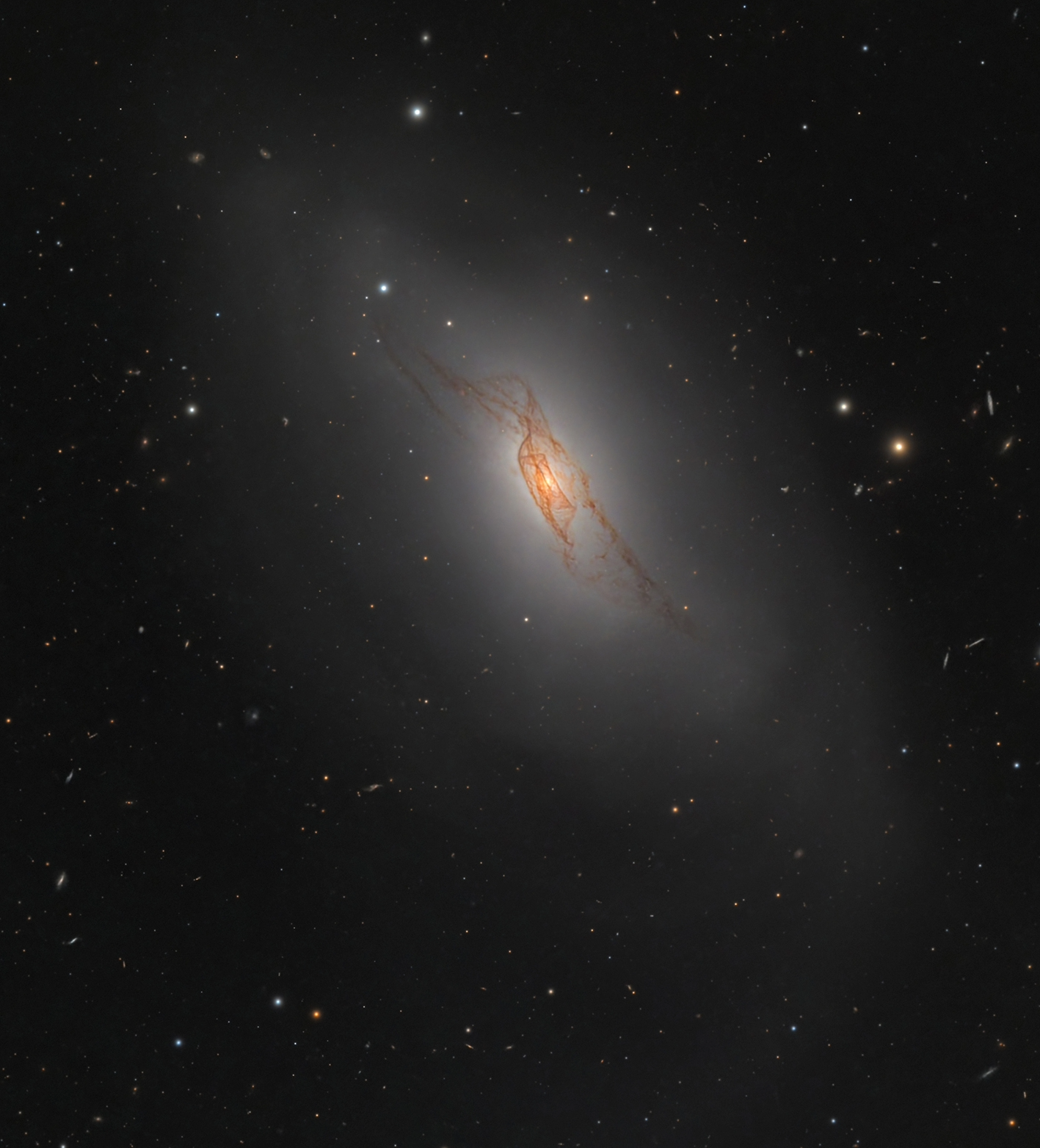 A lenticular galaxy with delicate dust lanes like a red veil A lenticular galaxy with delicate dust lanes like a red veil